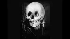 Ambiguous illusion showing a woman at a mirror that can also be seen as a human skull