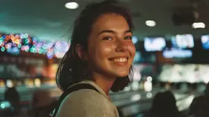 Young woman smiling in a bowling alley, illustrating genuine social smiling.