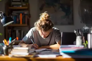 A person sitting at a desk in focused concentration, illustrating the psychology of sustained attention and deep work.