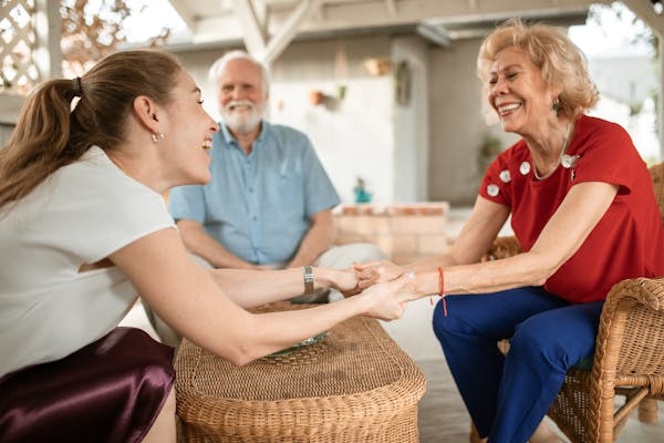 Young Woman and Her Elderly Parents Talking and Smiling