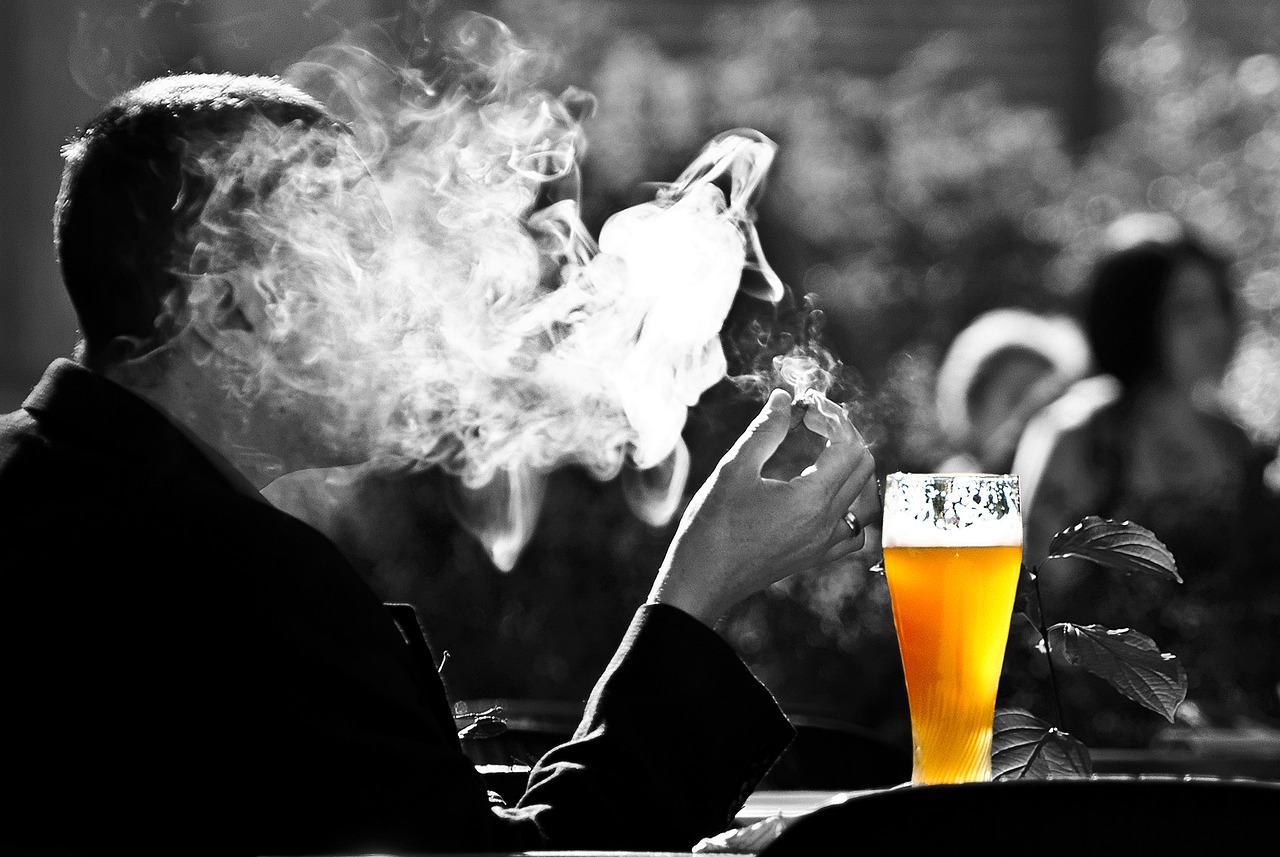 Man smoking and drinking.