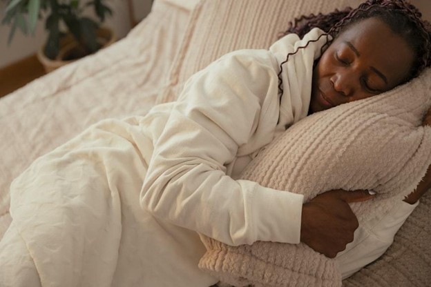 Person resting indoors showing fatigue and oversleeping, common symptoms of seasonal affective disorder during winter months.