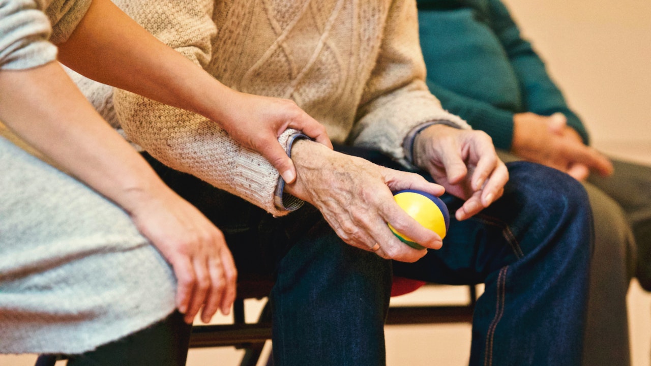 Senior in Group Therapy Holding a Stress Ball