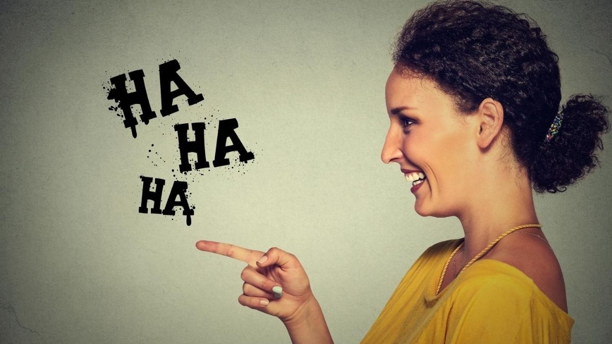 Person laughing as a visual representation of schadenfreude and social comparison Person laughing as a visual representation of schadenfreude and social comparison