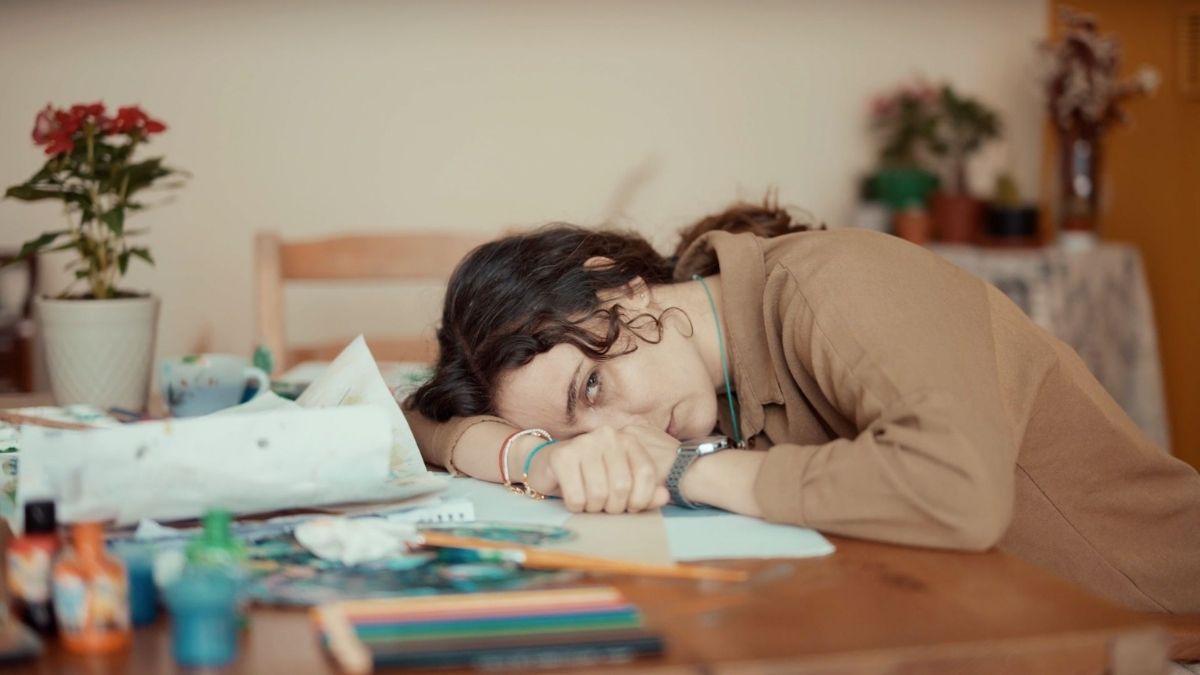 Person resting at a cluttered table, illustrating autistic inertia, task paralysis, and difficulty moving from intention into action. Person resting at a cluttered table, illustrating autistic inertia, task paralysis, and difficulty moving from intention into action.