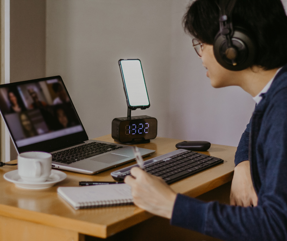 Person wearing headphones and using laptop for a Zoom call.